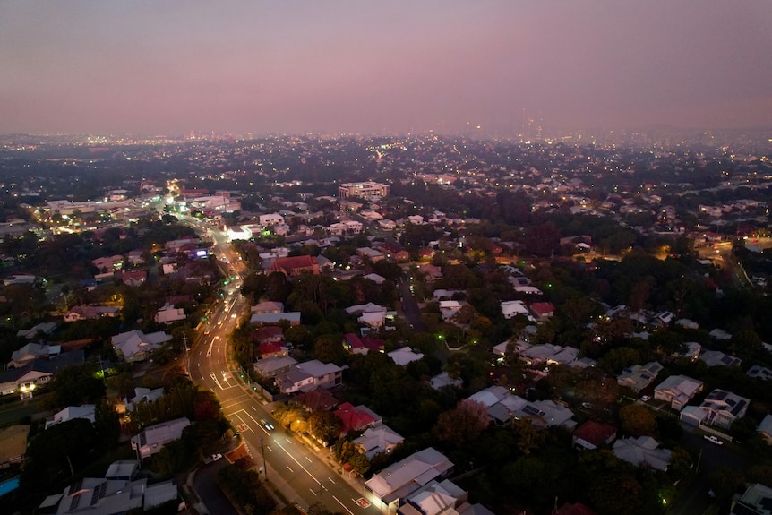 Drone pic west along Waterworks Rd from above Ashgrove, houses and roads on the foreground smoke covering city in the distance