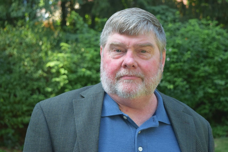 An older man in a polo shirt and blazer