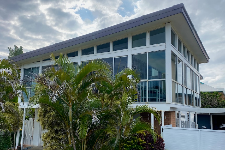 A two-storey house featuring huge windows and a slanted roof.