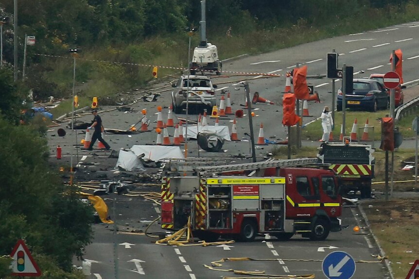 Emergency services and crash investigation officers work at the site where a Hawker Hunter fighter jet crashed