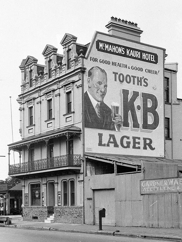 An early 1900s black-and-white photo of a hotel with a beer advertisement