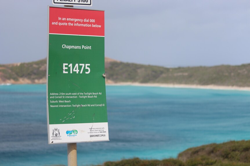 A sign shows the name Chapmans Point, Blue Haven beach is in the background