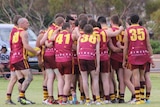 The Kambalda Eagles reserves side huddle during a game against Boulder Football Club in Kambalda last year. Exact date unknown.