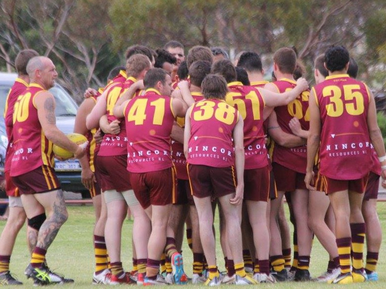 The Kambalda Eagles reserves side huddle during a game against Boulder Football Club in Kambalda last year. Exact date unknown.