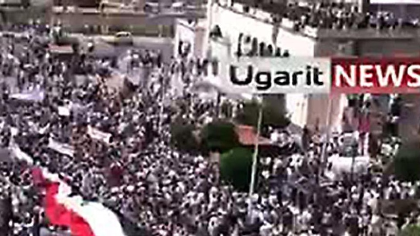 Anti-government protesters holding Syrian flags during a demonstration in the central city of Hama