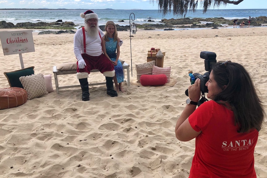 Santa on the beach photo being taken.