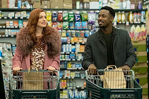 Anne Hathaway and Gary Carr push trollies side by side in the supermarket