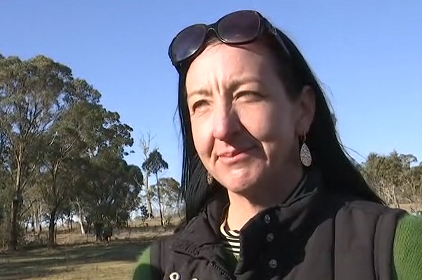 A woman in the outdoors talking.