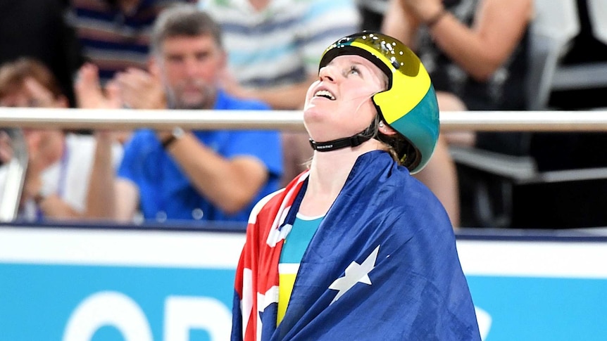 Morton, with the australian flag draped over her shoulders, looks to the roof of the stadium after her win