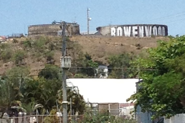 A sign that says Bowenwood, painted onto a water town on a hill side.