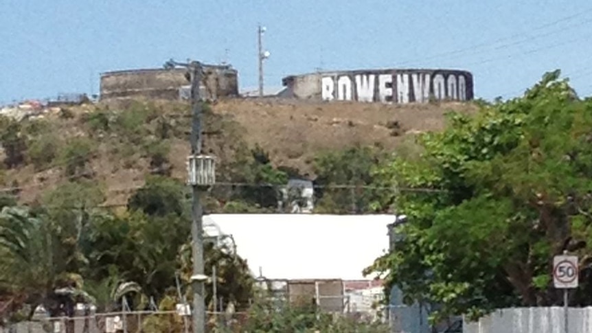 A sign that says Bowenwood, painted onto a water town on a hill side.