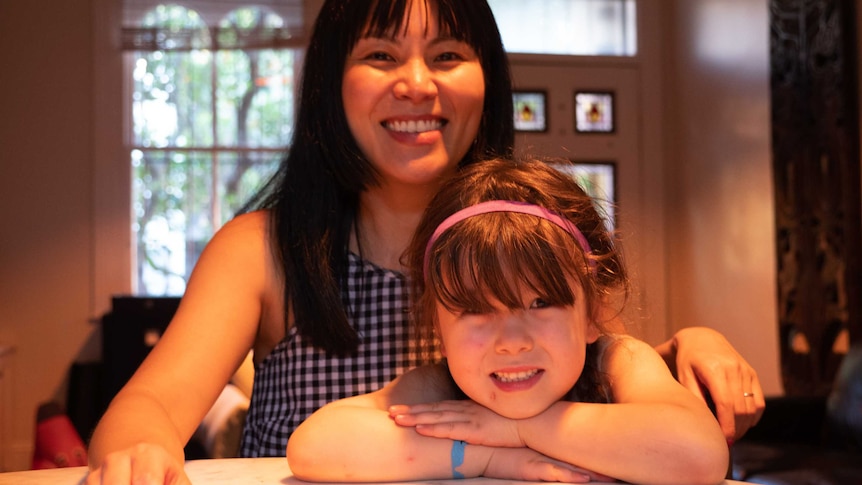 Imogen and Catherine Munkara-Kerr sit at their dining table.