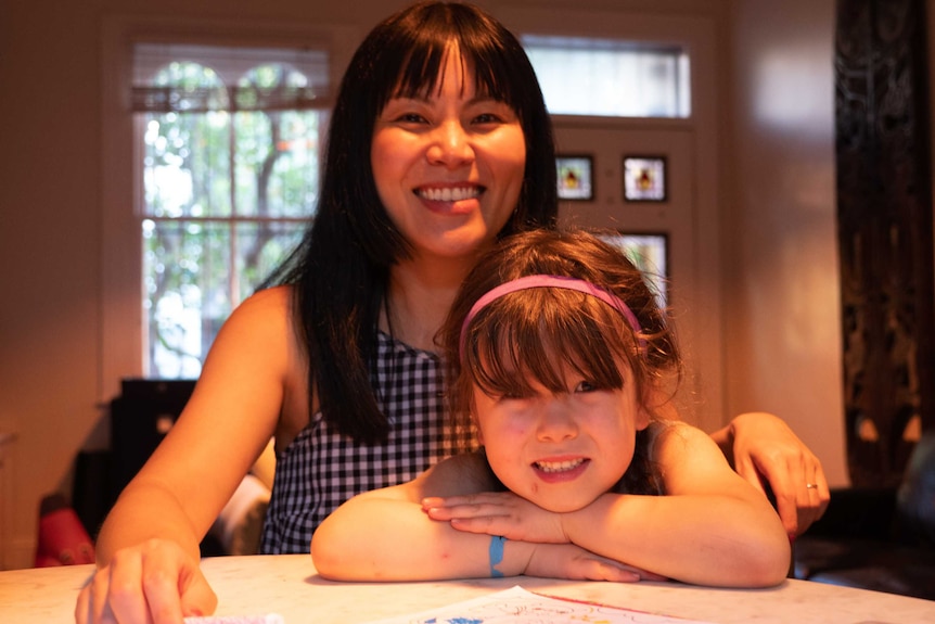 Imogen and Catherine Munkara-Kerr sit at their dining table.