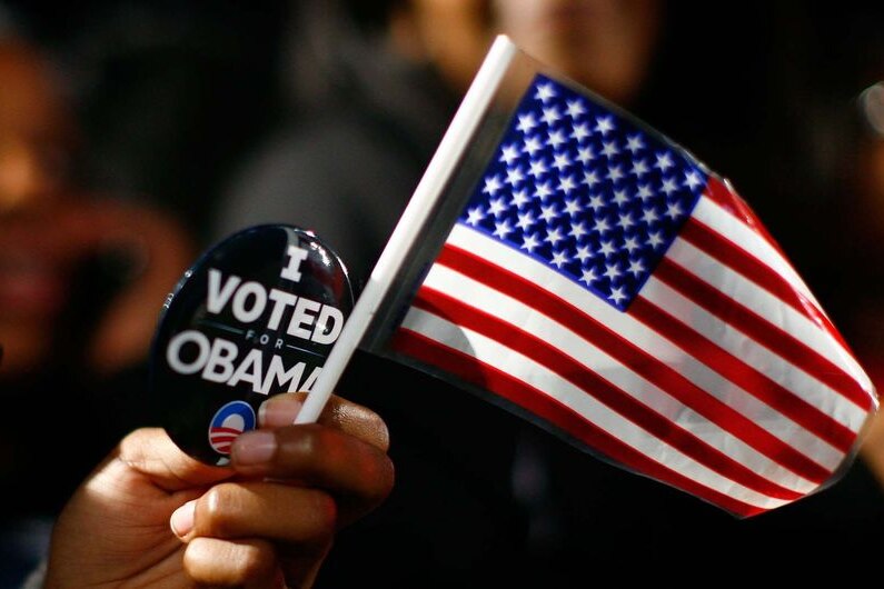 A Barack Obama supporter holds an American flag and a pin which reads 'I voted Obama' (AFP/Getty Images: Eric Thayer)