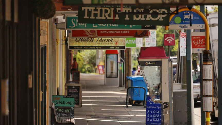 Deserted footpath along line of shops in Brisbane.