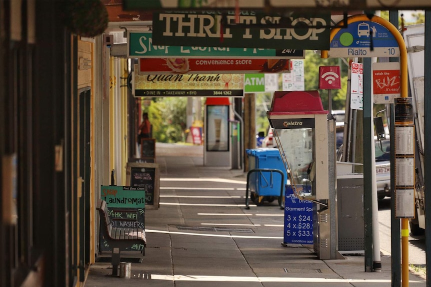 Deserted footpath along line of shops in Brisbane.