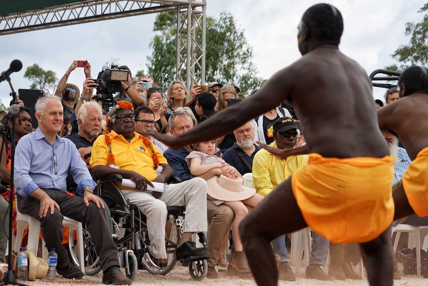 Malcolm Turnbull, Galarrwuy Yunupingu and Bill Shorten watch traditional Aboriginal dancers.