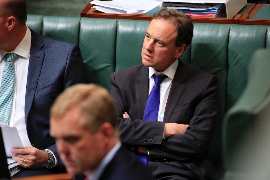 Minister for Health and Minister for Sport Greg Hunt sits beside Peter Dutton with his arms folded