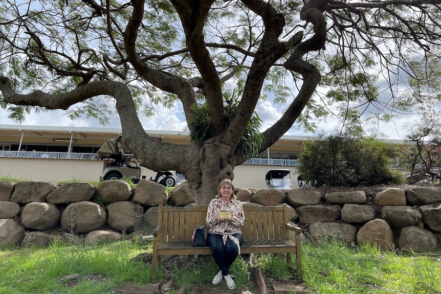Woman sitting in front of tree