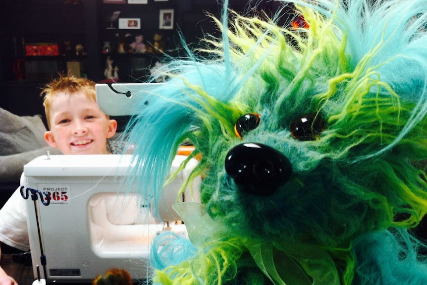 Campbell Remess at his sewing machine with one of his teddy bears in the foreground.