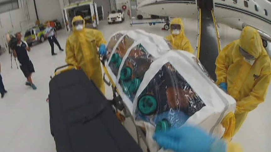 A mock Ebola patient in an isolation unit is transferred from a plane at Brisbane Airport.