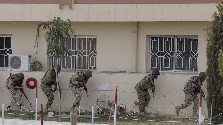 Pakistani paramilitary soldiers take position after militants attacked a hospital in Quetta.
