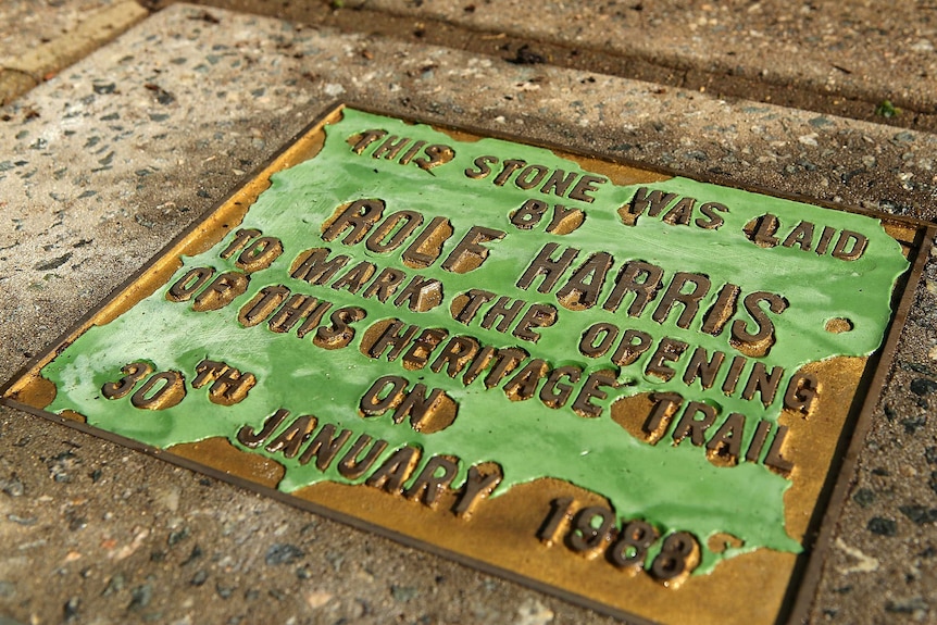 A footpath plaque commemorating Rolf Harris is pictured near the family's former residence on Bassendean Parade.