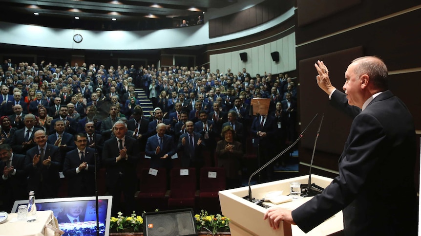 Turkey's President Recep Tayyip Erdogan gestures as he addresses the members of his party.