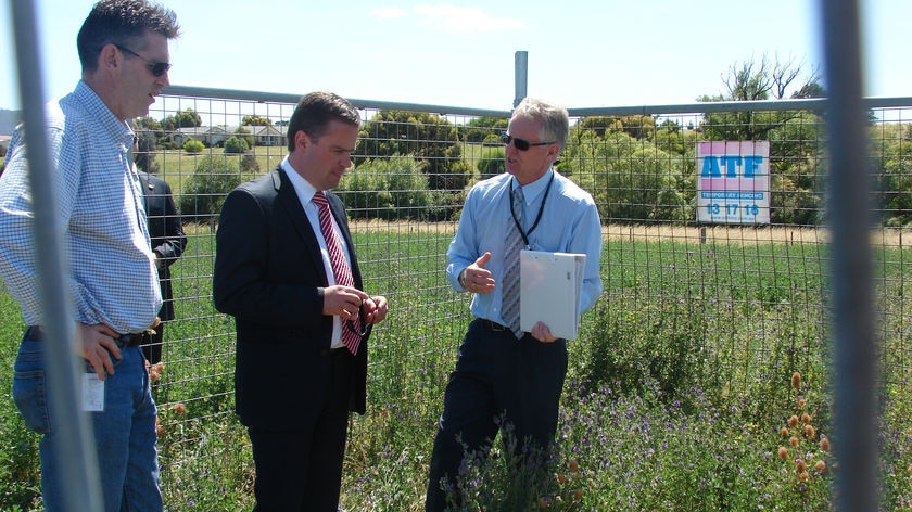 Tasmanian Premier David Bartlett stands in a fenced off area containing aboriginal relics.