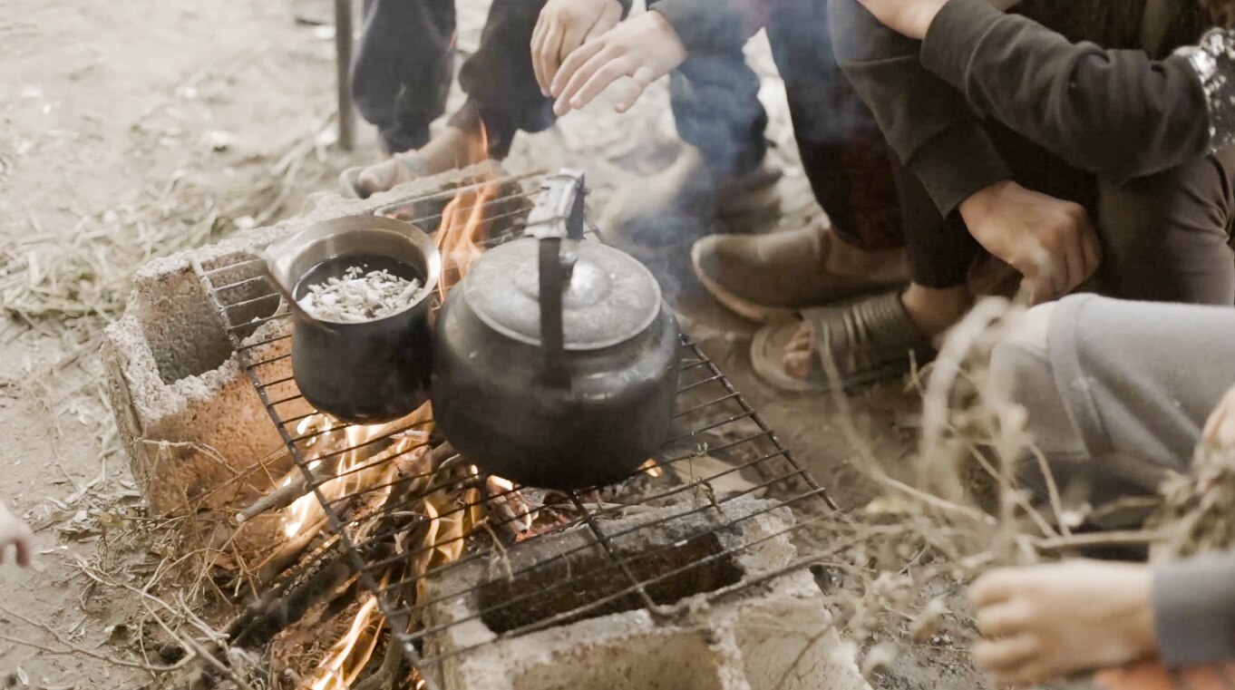 A clay pot on a makeshift stove made from sticks, bricks and a metal grate.Gaza