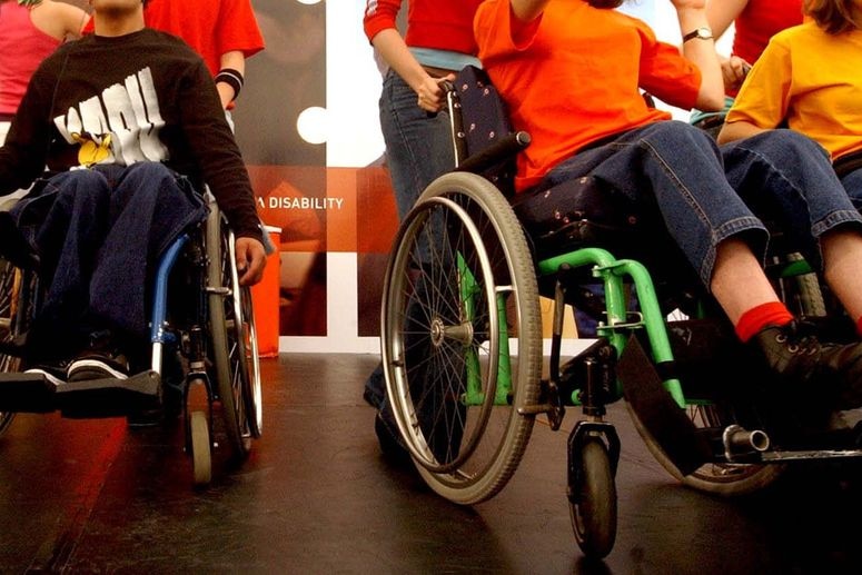 People in wheelchairs on a stage.