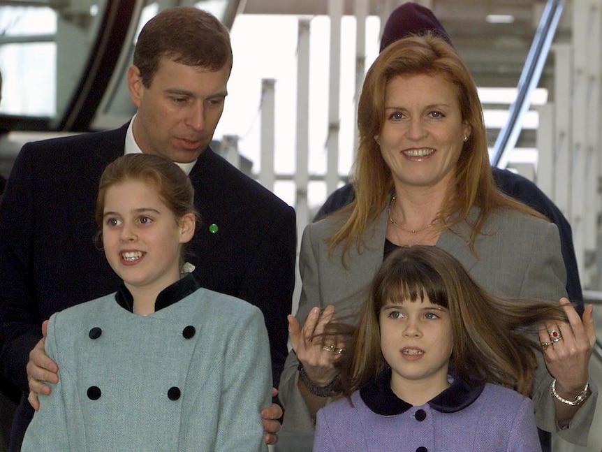 Prince Andrew and Sarah Ferguson stand behind their two children Eugenie and Beatrice. Sarah plays with Beatrice's hair