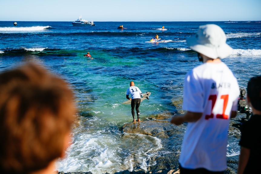 Kelly Slater dives off the rocks into the surf at the Margaret River Pro.
