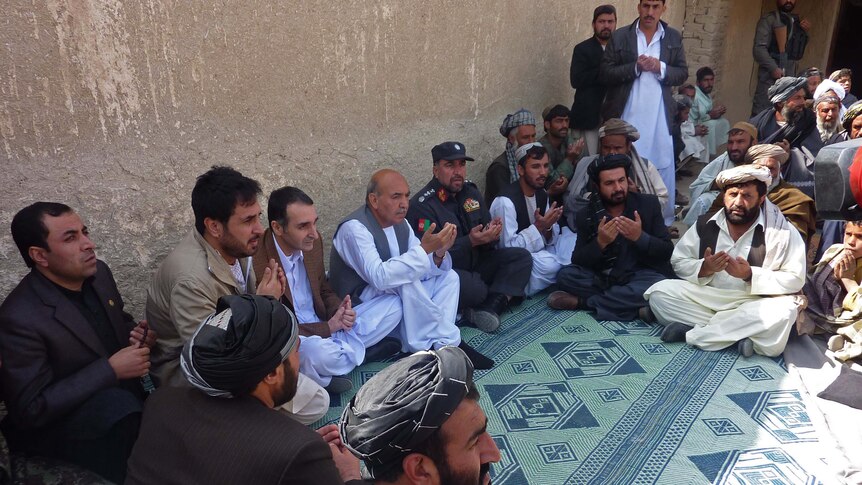 Afghan men pray for killing spree victims