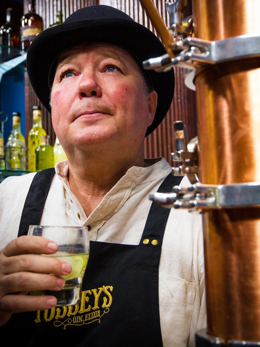 Man in a bowler hot drinking gin