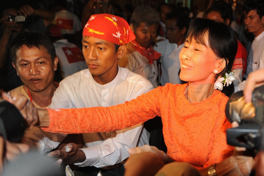 Aung San Suu Kyi shakes hands with supporters