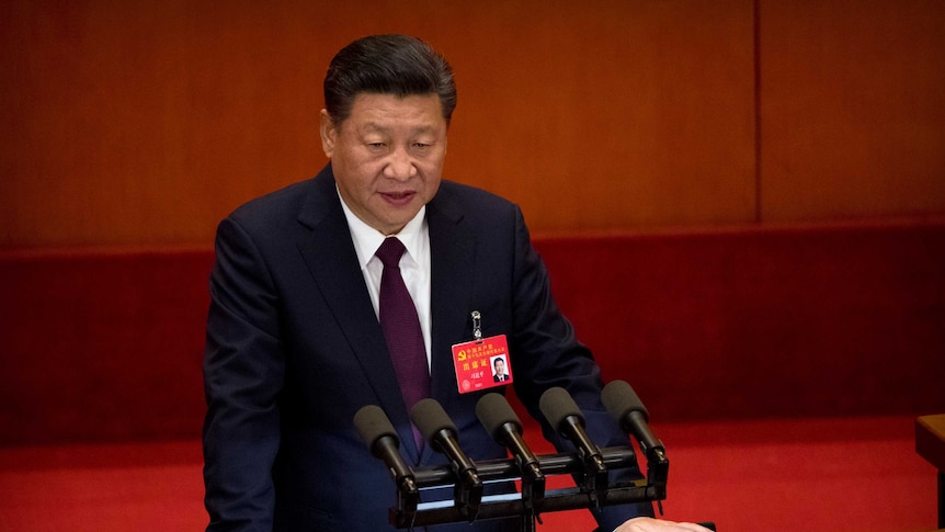 Chinese President Xi Jinping speaks into microphones at a podium.