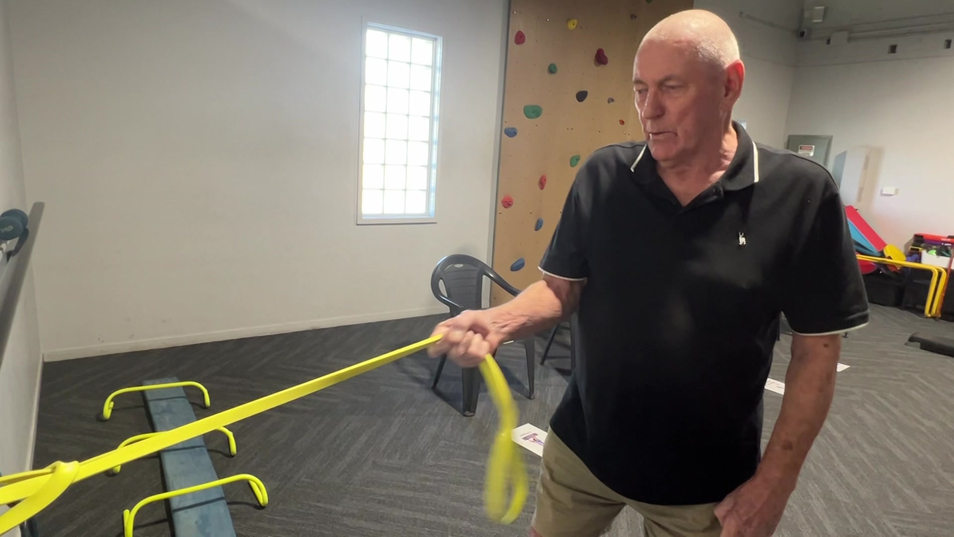 Um homem segurando uma corda elástica amarela.