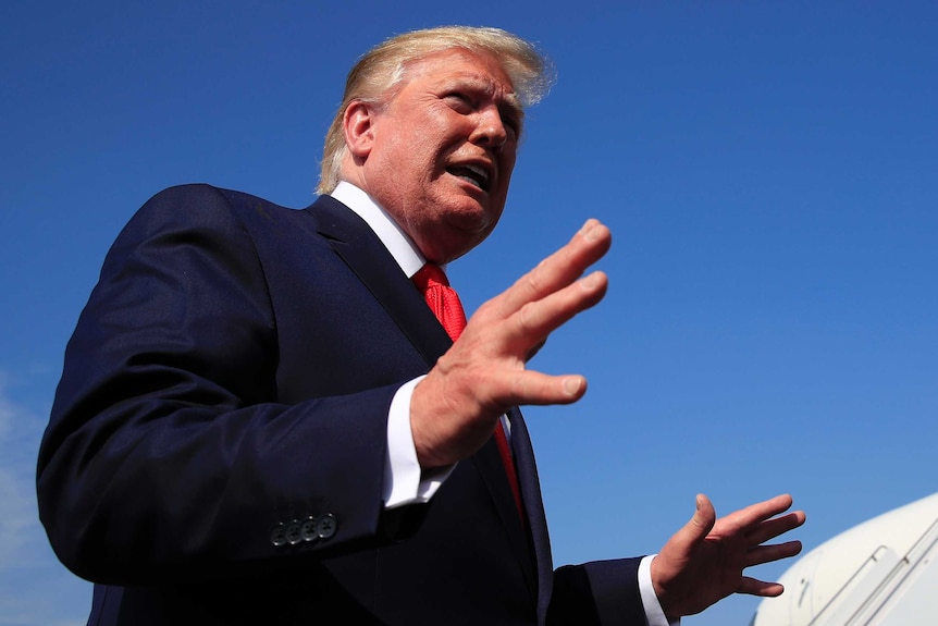 Trump shot from below as he speaks and gestures with his hands.