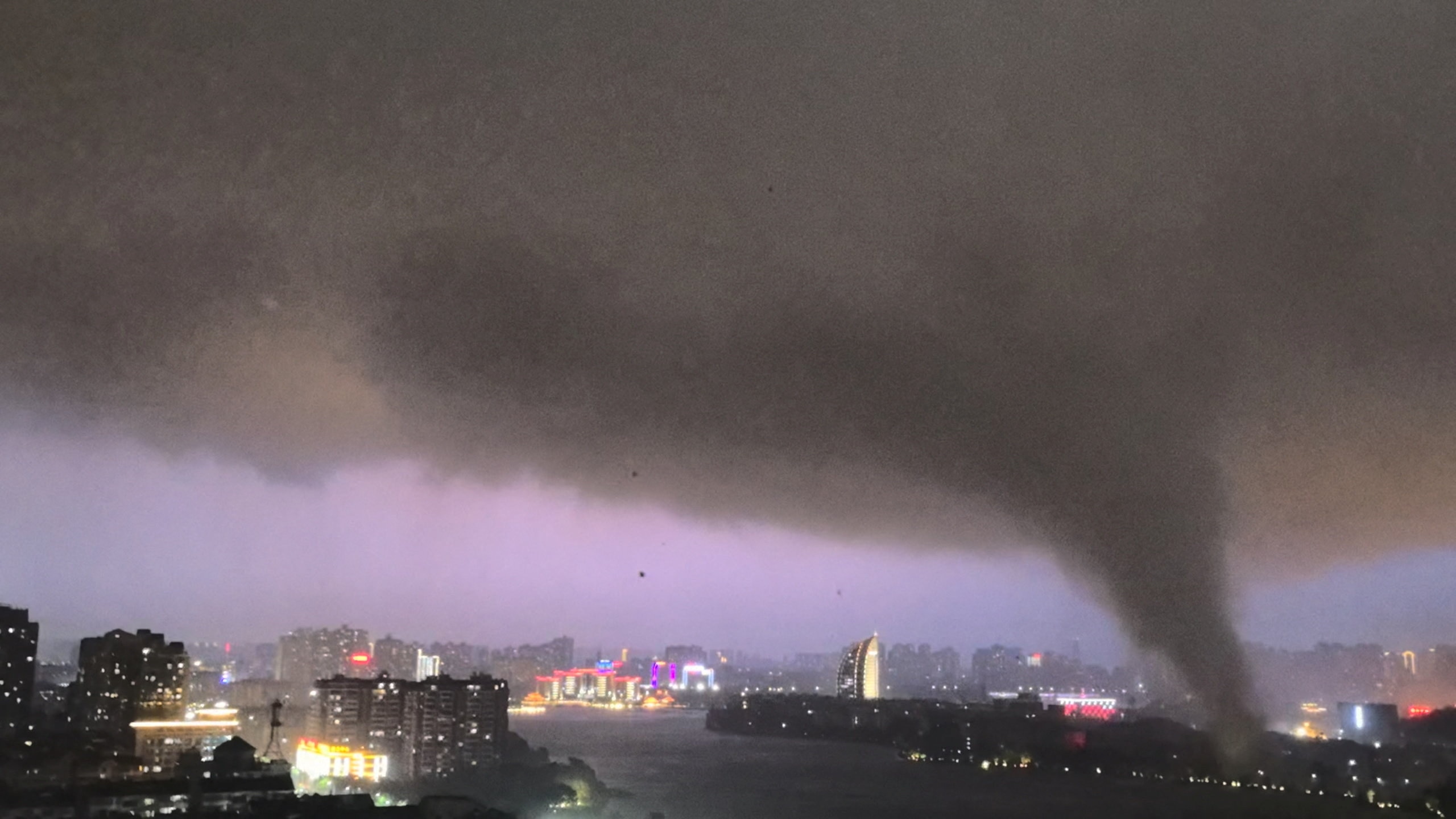 A black funnel over a city skyline.