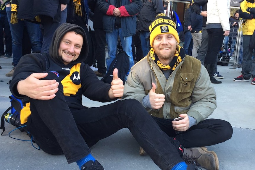 Richmond supporter Luke Saltmarsh queues with a friend outside the MCG.