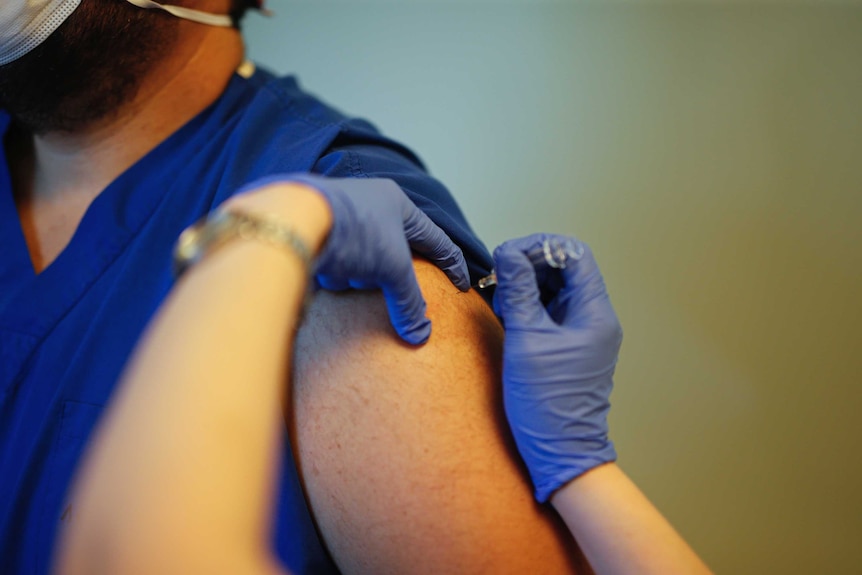 A doctor is administered a dose of a Chinese coronavirus vaccine in Turkey