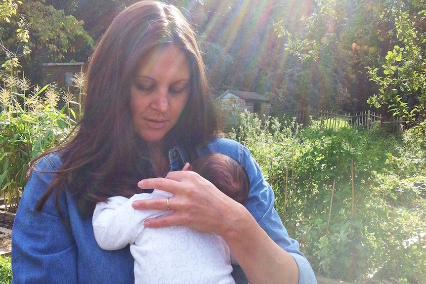 Josie Sargent holds her baby in the garden