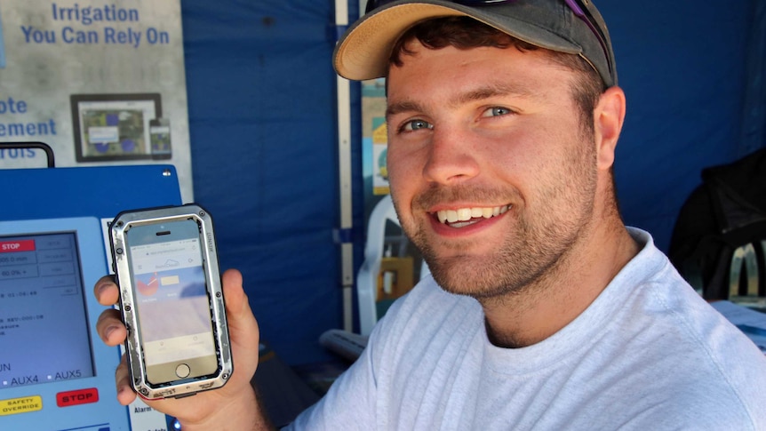 Remote irrigation monitoring system salesman Chris Connors shows off the app on his phone.