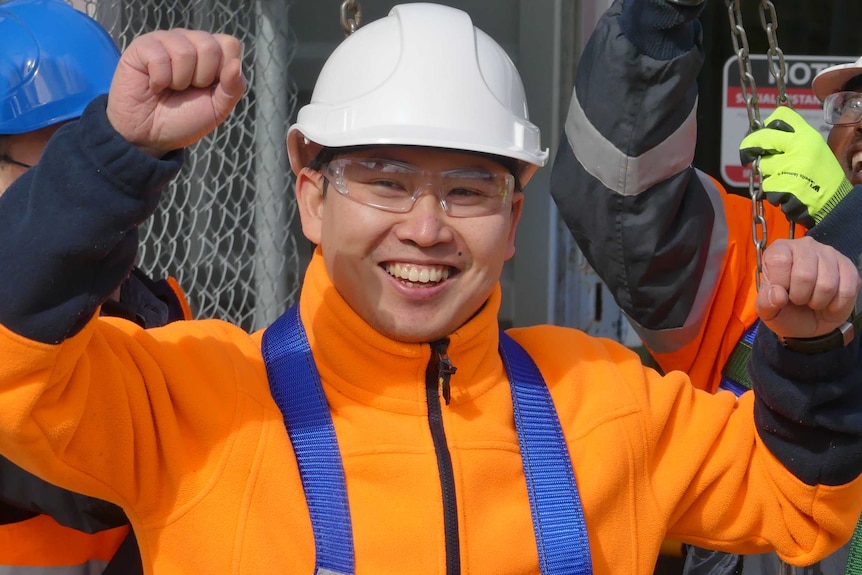 Migrant builder Huang Qinglong punches the air