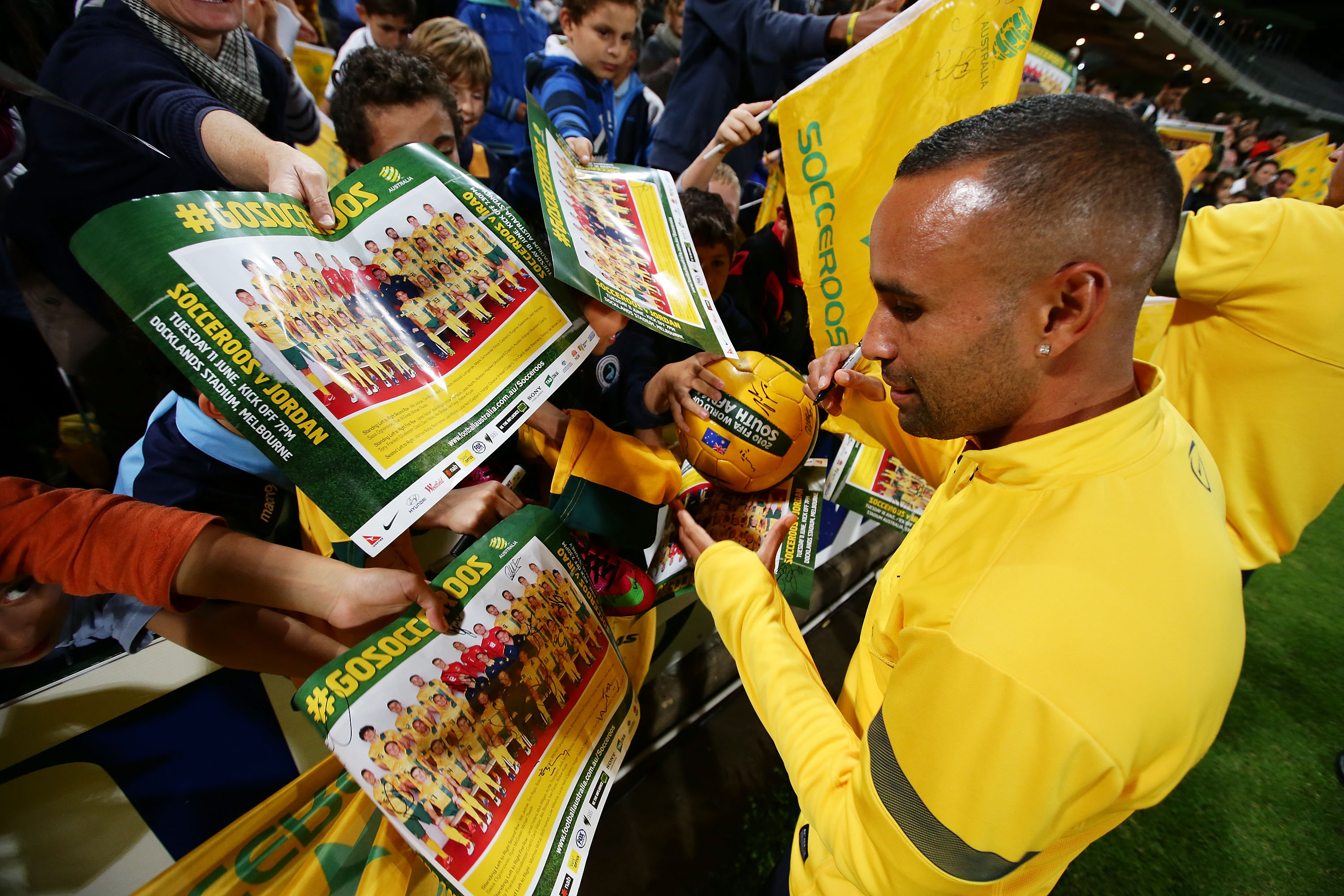 Archie Thompson dá autógrafos enquanto joga pelos Socceroos