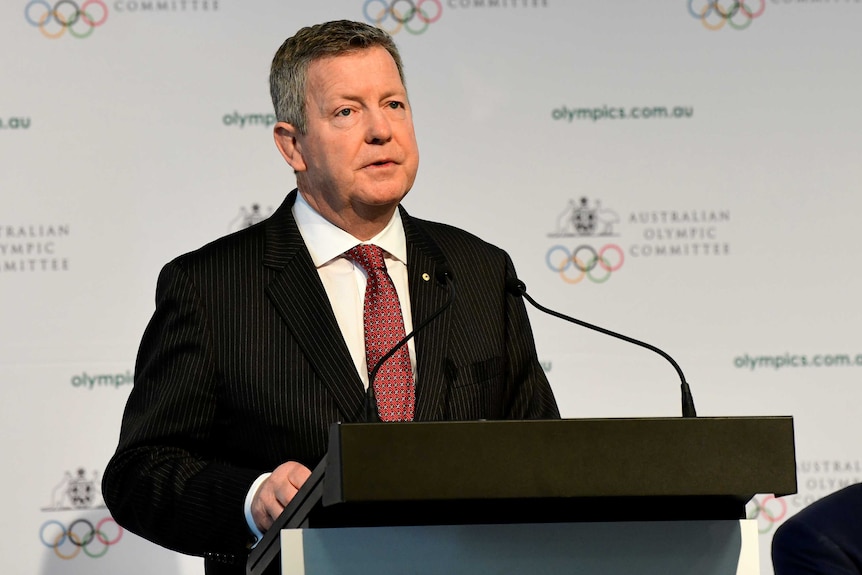 A sports executive stands at a lectern during an annual general meeting.