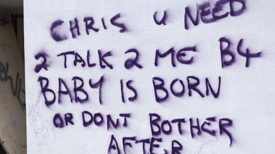 Graffiti sprayed onto a BBQ in a park reads 'Chris u need 2 talk 2 me b4 baby is born or dont bother after'.