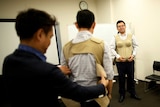 Participants try to wear 7-kilogram pregnancy jackets as they take part in an "Ikumen" course, or child-rearing course for men