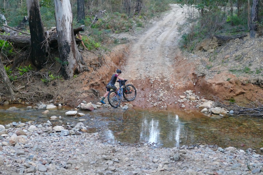 Femme à vélo traverse la rivière